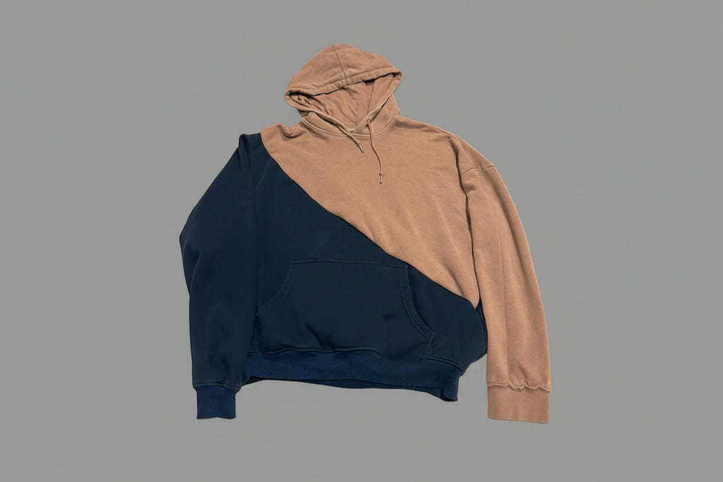 Two-tone hoodie tan hooded and navy blue body on grey back splash